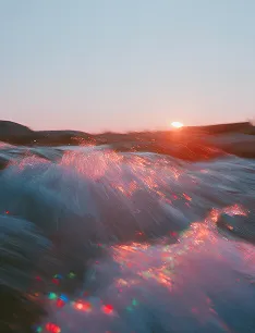 Sunset over flowing river water creating a shimmering effect with blurred motion.